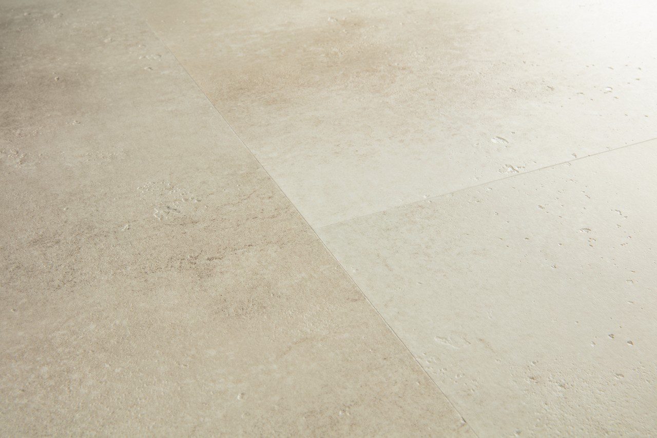 Vinyylilattia Quick-Step Illume Sandstone Concrete asennettuna kodin lattialle – lämmin hiekkabeige/greige sävy ja hillitty, luonnollisen kivimäinen betonidesign hienovaraisella tekstuurilla.