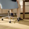 laminat-quick-step-impressive-design-nutmeg-oak Laminat Quick Step Impressive Suunnittelu Nutmeg Oak, verlegt im Büro, blauer Bürostuhl mit sitzendem Mann