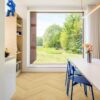 ламинат-елка-quick-step-impressive-design-nutmeg-oak Ламинат ёлочкой Quick Step Impressive Suunnittelu Nutmeg Oak, уложен на кухонный пол, белый обеденный стол с синими стульями и вазой с цветами