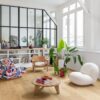 LVT parkett Quick-Step Bloom Elegant Oak Natural paigaldatud elutoa põrandale, riiul, laud, toolid ja vinüülplaadimängija.