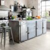 lvt-parkett-quick-step-blos-canyon-tamm-saw-cuts LVT parkett Quick-Step Blos Cayon tamm grey saw cuts paigaldatud köögi põrandale. Metallist köögimööbel ja köögisaar.