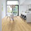 lvt-porandakate-quick-step-blos-drift-tamm-beige LVT põrandakate Quick-Step Blos Drift tamm beige paigaldatud köögi põrandale. Valge köögimööbel, köögisaar koos musta värvi toolidega. Ümar söögilaud koos valgete toolidega.