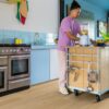 LVT Quick-Step Blos Coast Oak Beige installed on a kitchen floor. Man is making a smoothie.