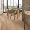 fertigparkett-bauwerk-boen-casapark-eiche-46-vivo-gebuerstet-osmo-hartwachsoel-138mm Fertigparkett Bauwerk Boen Casapark Eiche 46 Vivo (138 mm), gebürstet und mit Osmo Hartwachs-Öl geölt – verlegt im Flur und Essbereich; Holzesstisch mit Holzstühlen und gedecktem Tisch, rustikale Flurwände in Betonoptik. Rustikale Sortierung mit lebendiger Maserung und Astanteilen.