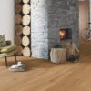 naturaalparkett-bauwerk-casapark-budget-cut-tamm-35-harjatud-matt-lakk Naturaalparkett Bauwerk Casapark Budget Cut harjatud matt lakk paigaldatud koridori ja elutoa põrandale. Suur kiviga kaetud kamin milles tuli.