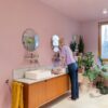 vinyl-tiles-quick-step-oro-coral-rock Vinyl tiles Quick-Step-Oro-Coral Rock installed on bathroom floor. Double bathroom furniture and woman washing her teeth looking to mirror.