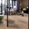 Tammeparkett Bauwerk Casapark tamm 46 Crema ültra matt lakitud, harjatud paigaldatud modernse elutoa põrandale. Lilla diivan 