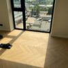 Kalanruotoparketti Bauwerk Monopark Tammi Natur 15 Avorio asennettuna huoneeseen, jossa lattiaan asti ulottuva ikkuna ja auringonvaloa lattialla